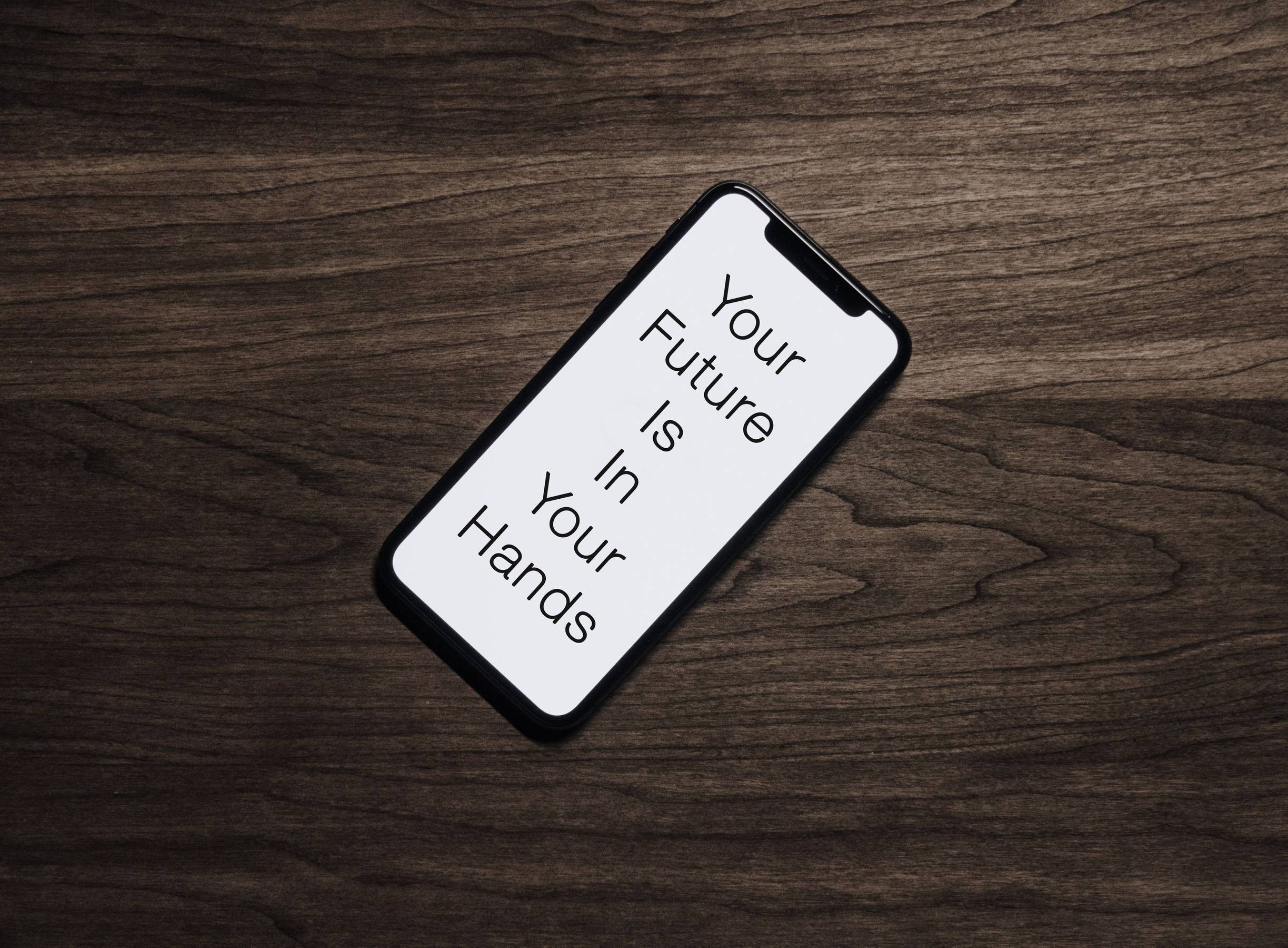 A smartphone with "Your Future Is In Your Hands" on the screen
